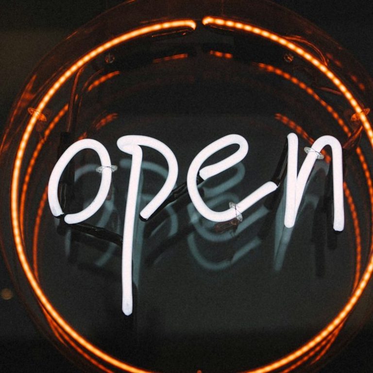 Agencia de marketing abierta cartel luminoso. Cartel luminoso que dice "abierto" en letras blancas sobre fondo oscuro. Imagen referida a abierta agencia de Marketing Experience.